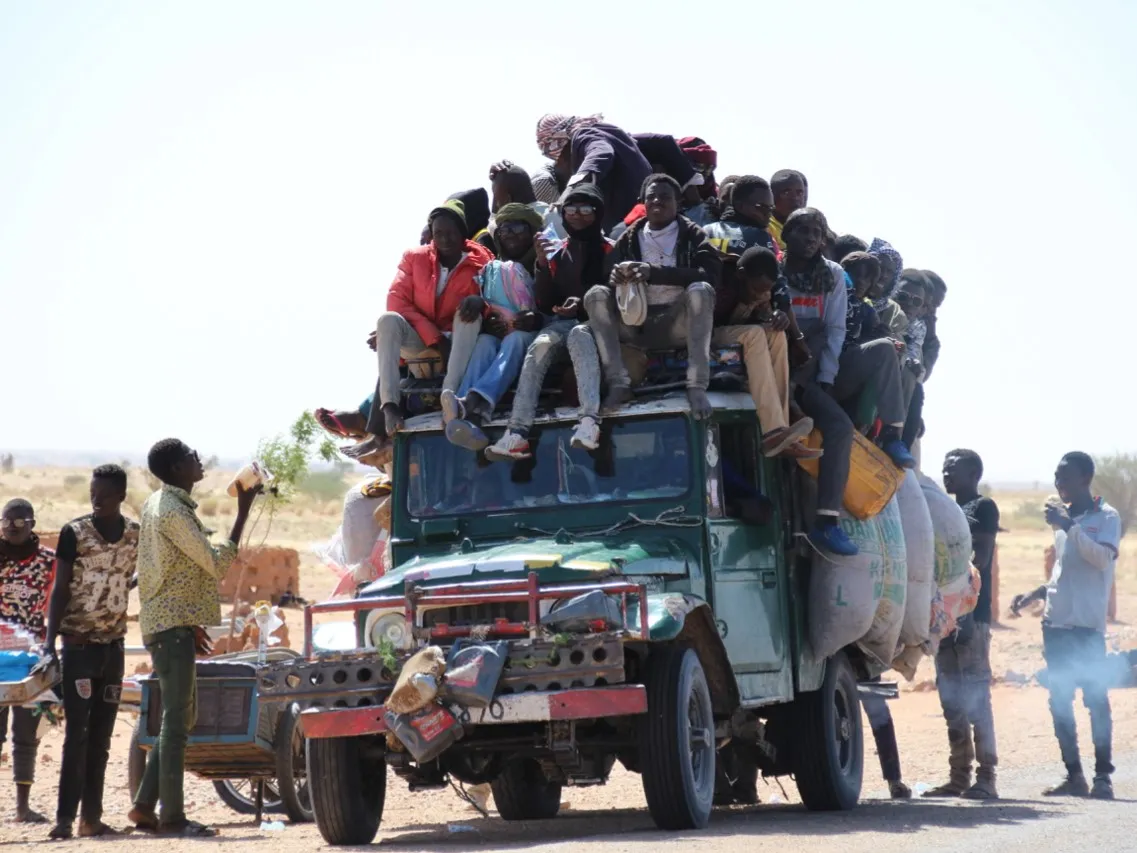 Numerous people atop a jeep in Niger leaving because of food insecurity or lack of work related to changes in agricultural yields linked to climate change. Credit: Kevin Uno
